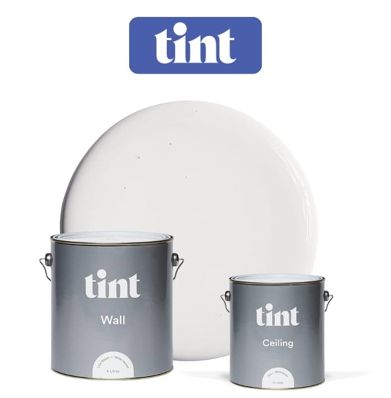 Tint interior wall and ceiling paints in sleek grey cans, set in front of a soft white paint swatch.