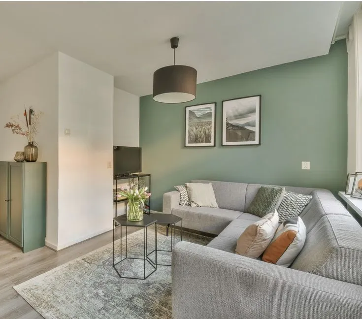 A modern living room painted in a warm greige , showcasing a 2025 interior paint colour trend
