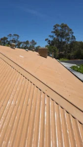 A faded tan corrugated metal roof showing signs of ageing and weather exposure before undergoing professional roof painting and repair services in Bendigo.