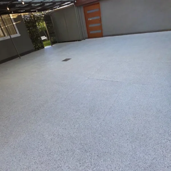 A wide-angle view of a freshly coated light grey epoxy floor in an outdoor patio area, showing a seamless and modern finish in Bendigo.
