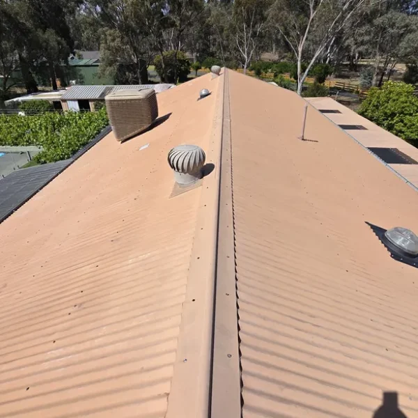 A faded tan metal roof with visible wear before receiving professional roof painting and repair services in Bendigo, highlighting deterioration and colour loss.
