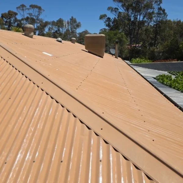 A faded tan corrugated metal roof showing signs of ageing and weather exposure before undergoing professional roof painting and repair services in Bendigo.