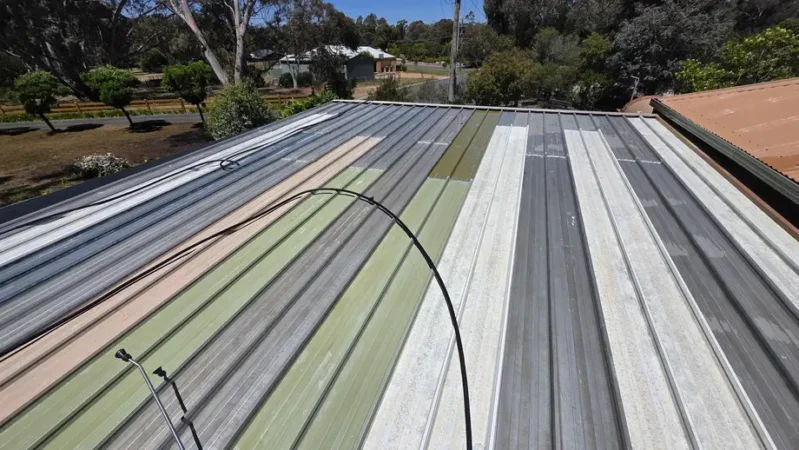 A weathered metal roof with faded multi-coloured panels showing signs of deterioration before receiving professional roof painting and repair services in Bendigo.