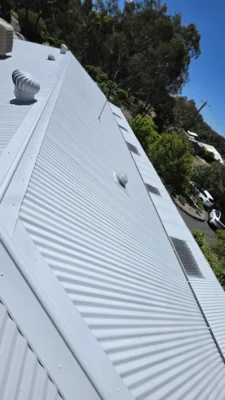 A newly painted white corrugated metal roof reflecting sunlight after receiving professional roof painting and repair services in Bendigo, creating a clean and modern appearance.