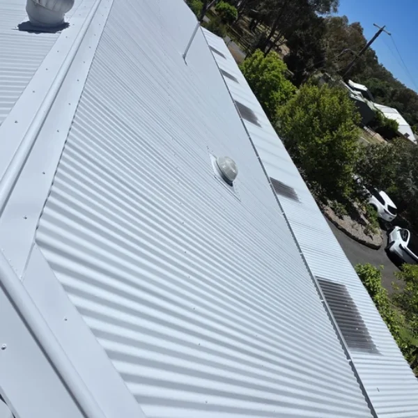 A newly painted white corrugated metal roof reflecting sunlight after receiving professional roof painting and repair services in Bendigo, creating a clean and modern appearance.